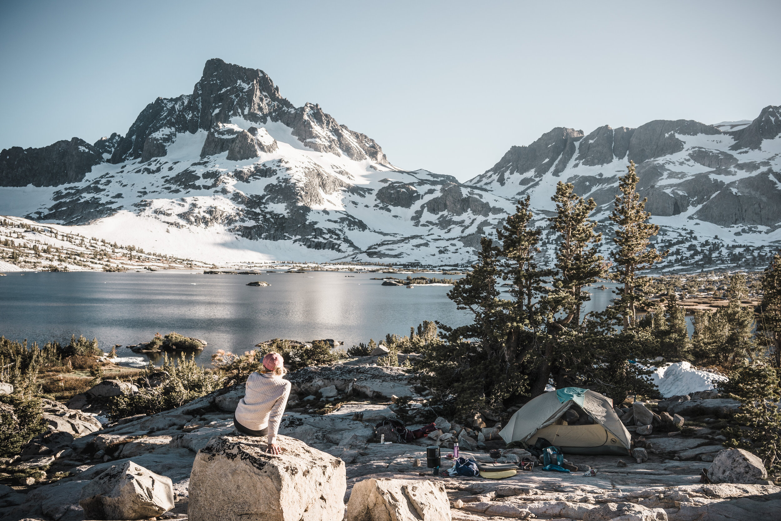 Sarah Herron sitting at camp in front of Thousand Island Lake – a large alpine lake in the Sierra Nevada, within the Ansel Adams Wilderness in eastern Madera County, California. Summer backpacking trip via June Lake Loop &amp; Minarets Loop.