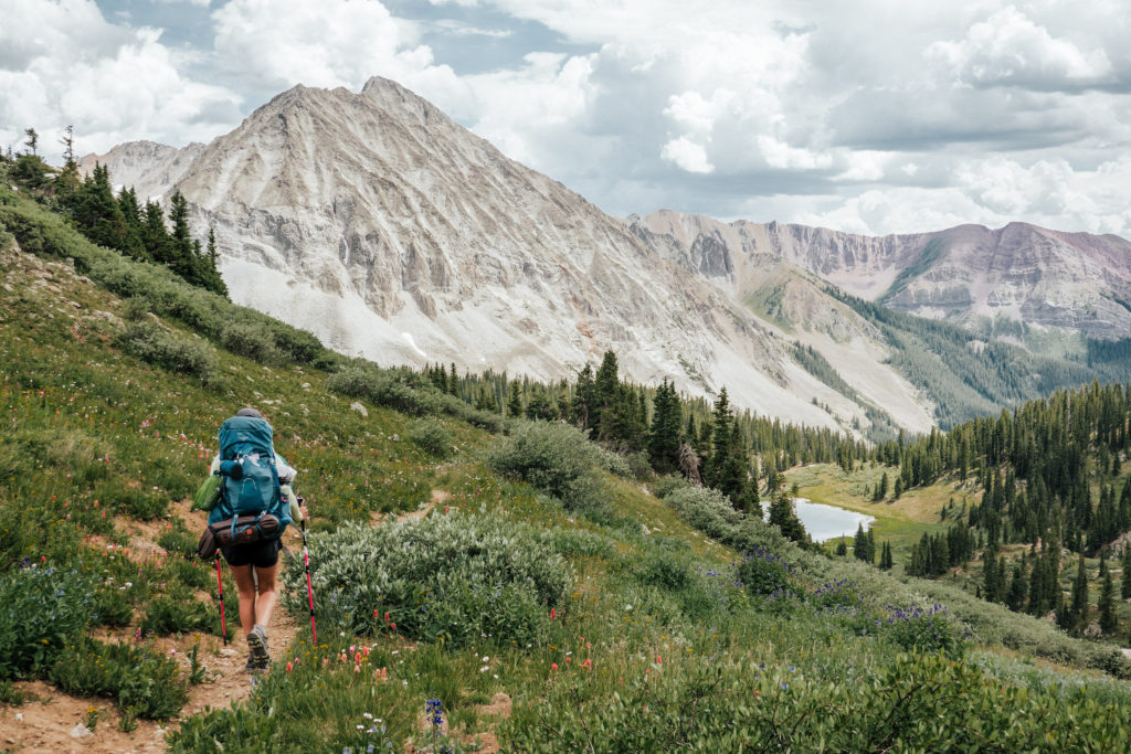 A woman is backpacking in the high alpine range of along the East Maroon Pass from Aspen to Crested Butte