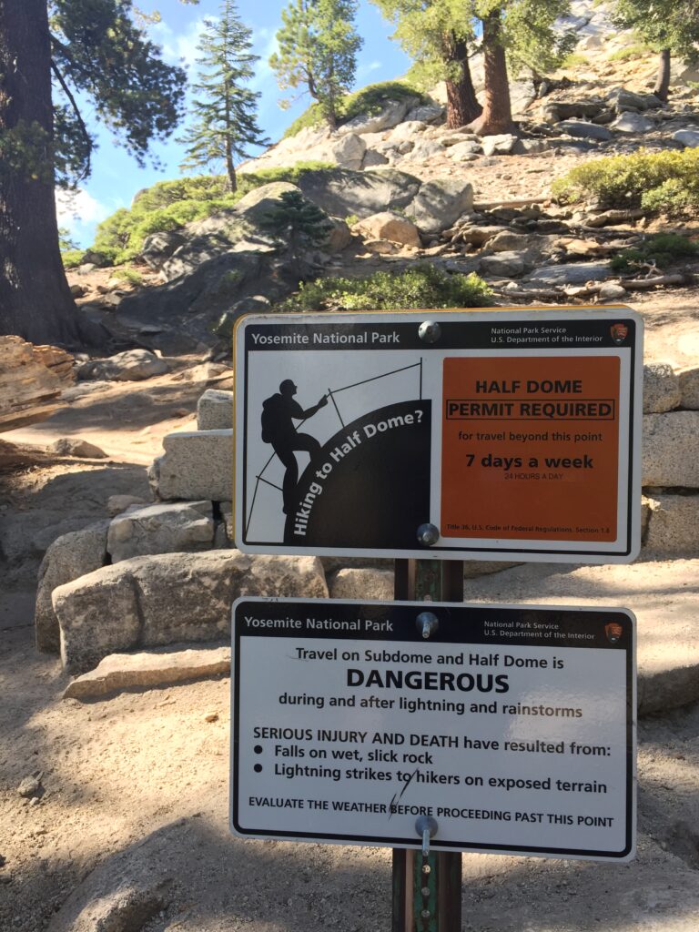 A trail sign informing hikers that permits are required on the Half Dome Cables of Yosemite National Park