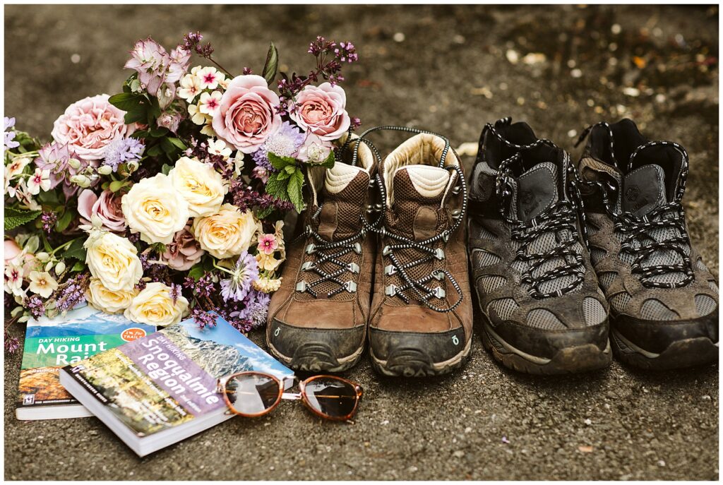 a pair of hiking boots arranges with wedding bouquet and hiking guide books for Mount Rainer